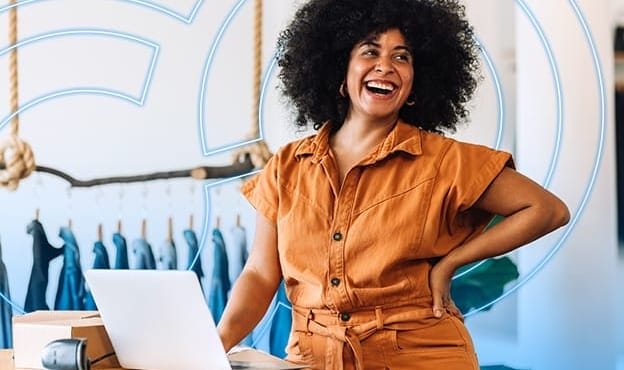 Fashion retailer in stylish workspace using laptop