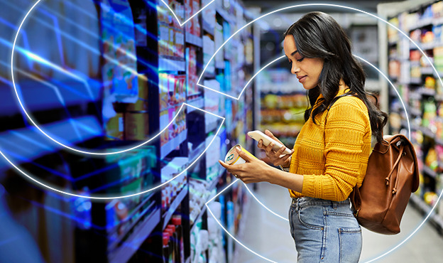 Shopper reading food packaging while holding two items in a grocery store