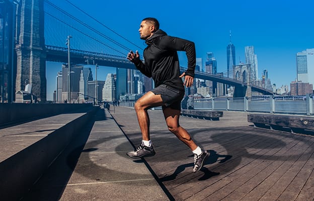Man running up steps with city in the background