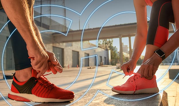 2 people tying their bright colored running shoes