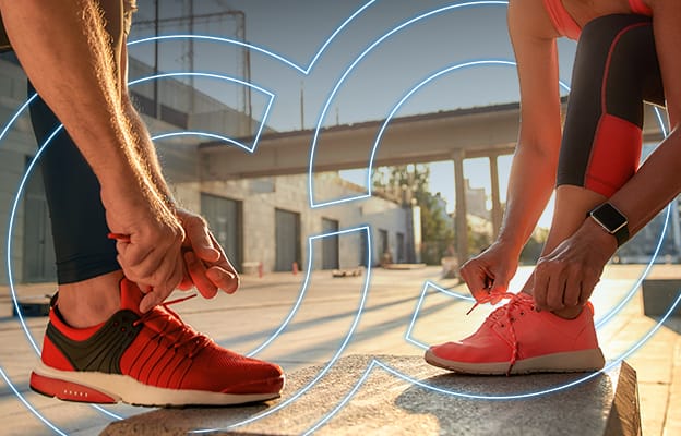 2 people tying their bright colored running shoes