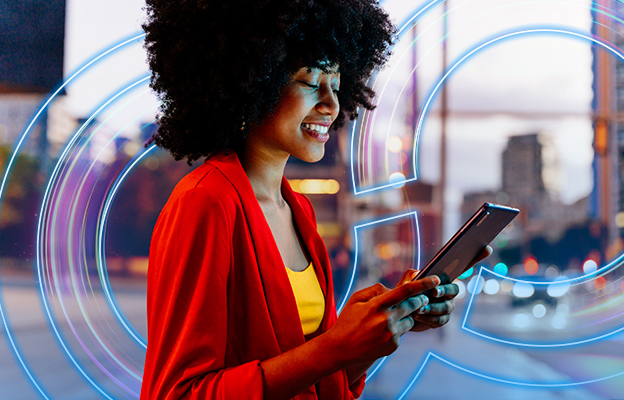Modern businesswoman smiling while connected on digital tablet outside